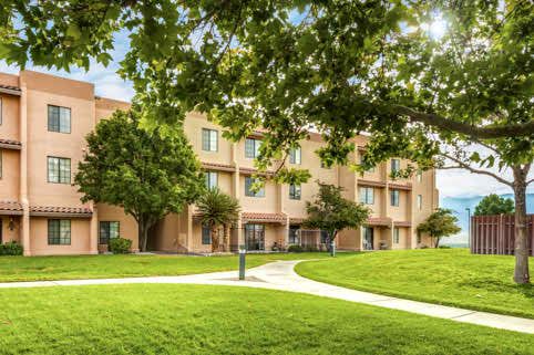 A building surrounded by lush greenery and a winding pathway.