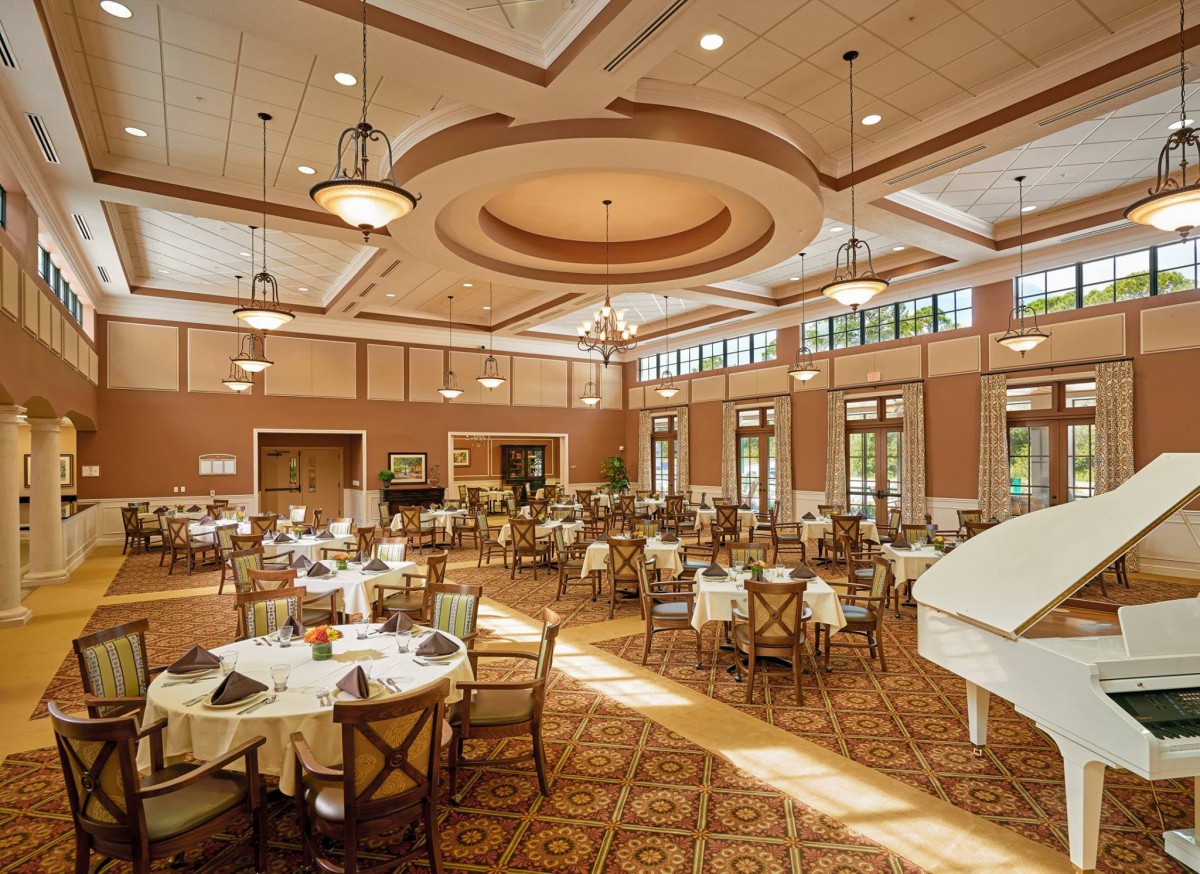 An elegant dining hall with beautifully set tables and warm lighting.