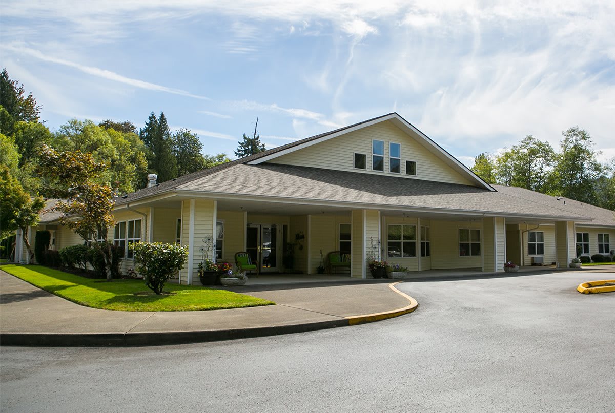 A single-story residential building with a driveway and well-maintained lawn in a suburban setting.