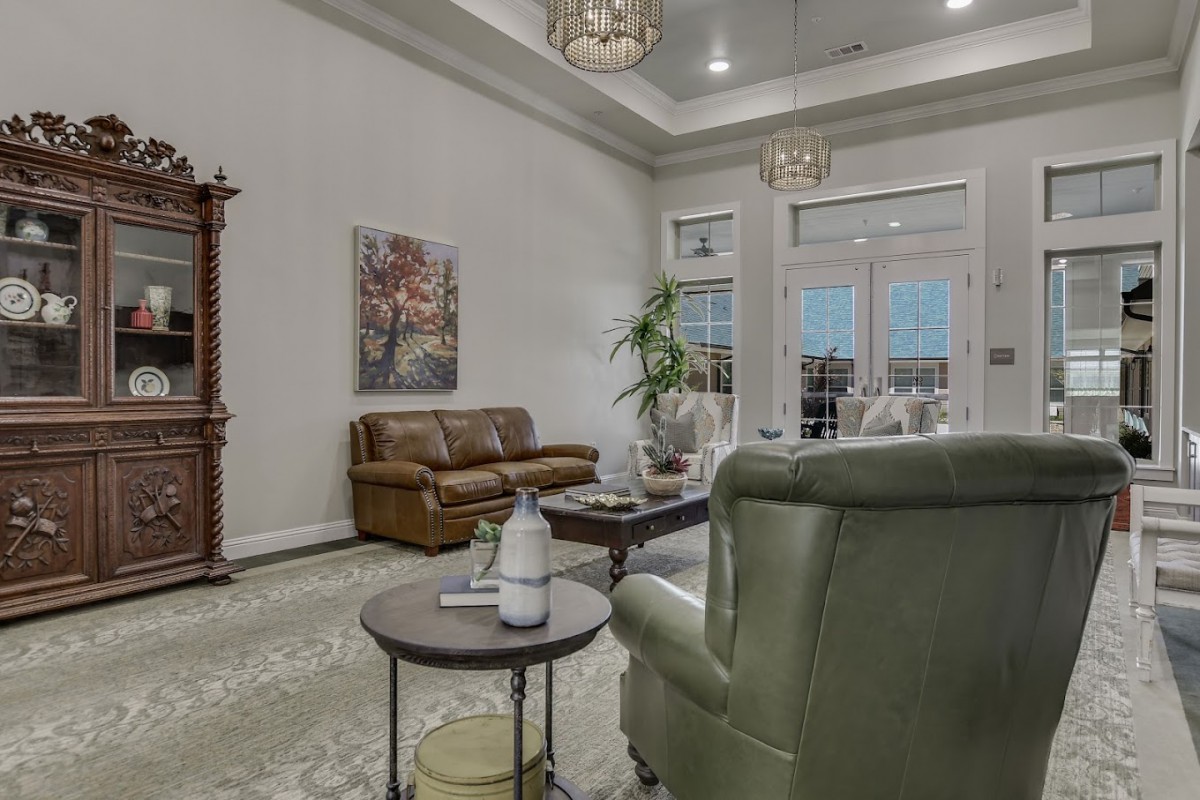 A cozy living room with a sofa, armchair, and coffee table, featuring elegant decor and soft lighting.