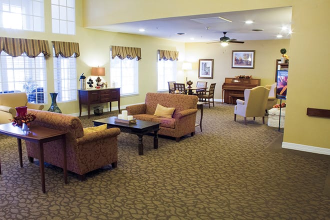 A cozy living room with sofas, chairs, and a carpeted floor.