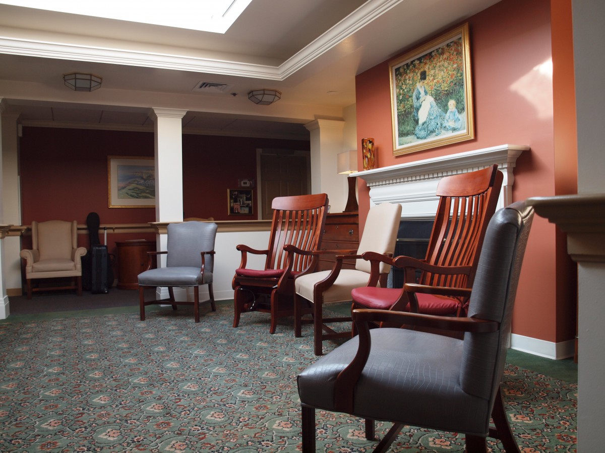 A quiet waiting room with several chairs and a painting on the wall.