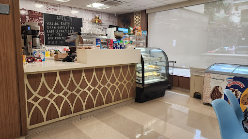 An inviting cafe interior featuring a dessert display and a stylish counter.