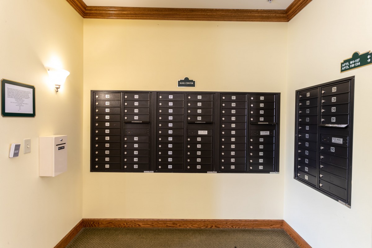 A wall with multiple mailboxes in an apartment building.