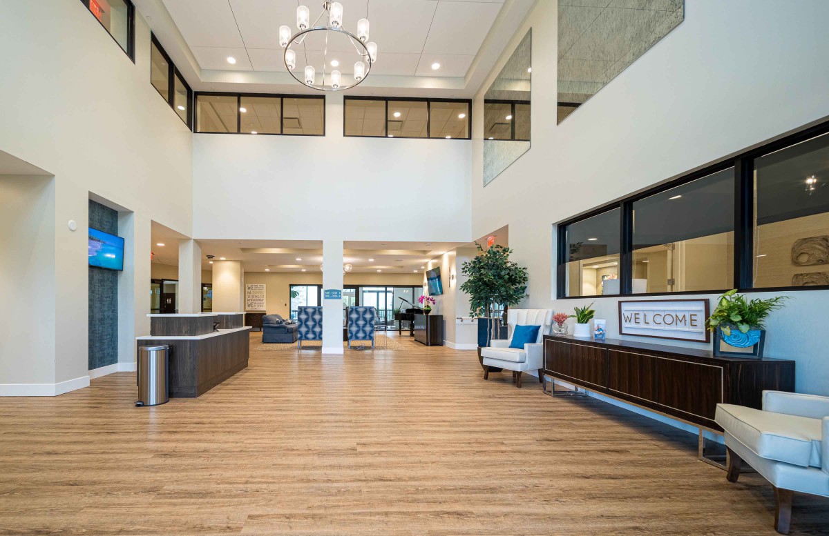 A spacious and modern lobby with elegant interior design, featuring a reception desk and comfortable seating.