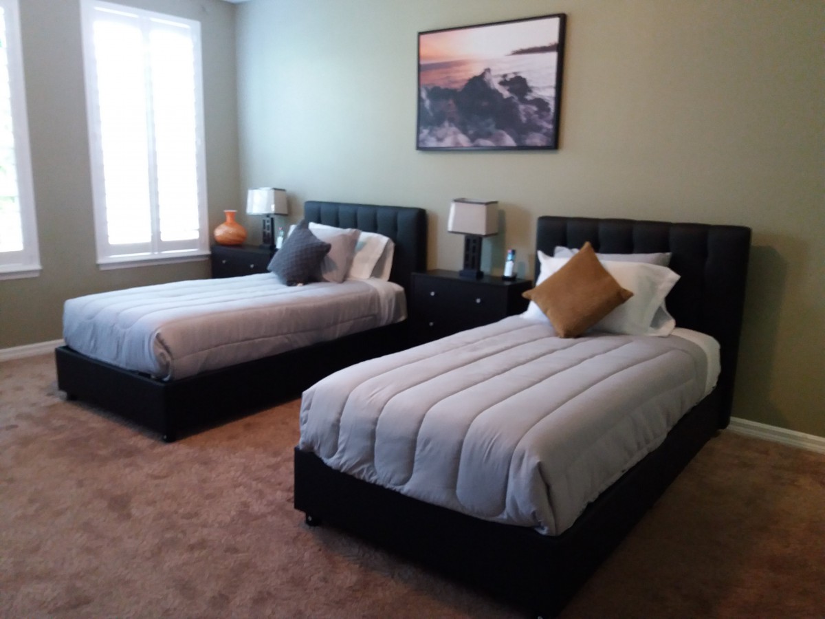 A neatly arranged bedroom with twin beds and elegant decor.