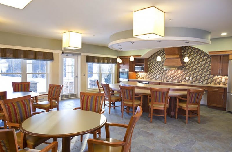 A modern kitchen and dining area with stylish lighting and wooden furniture.