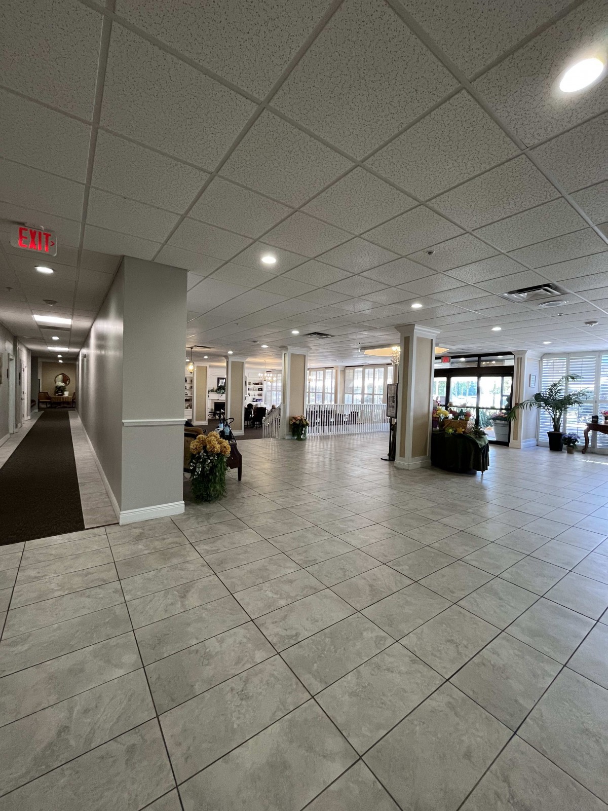 Spacious and modern lobby with tiled flooring and decorative plants.
