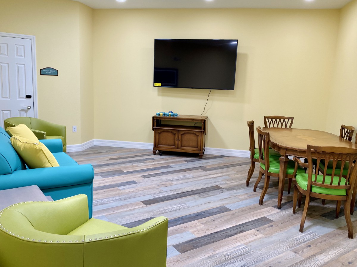 A cozy living room with a television, seating area, and wooden table.