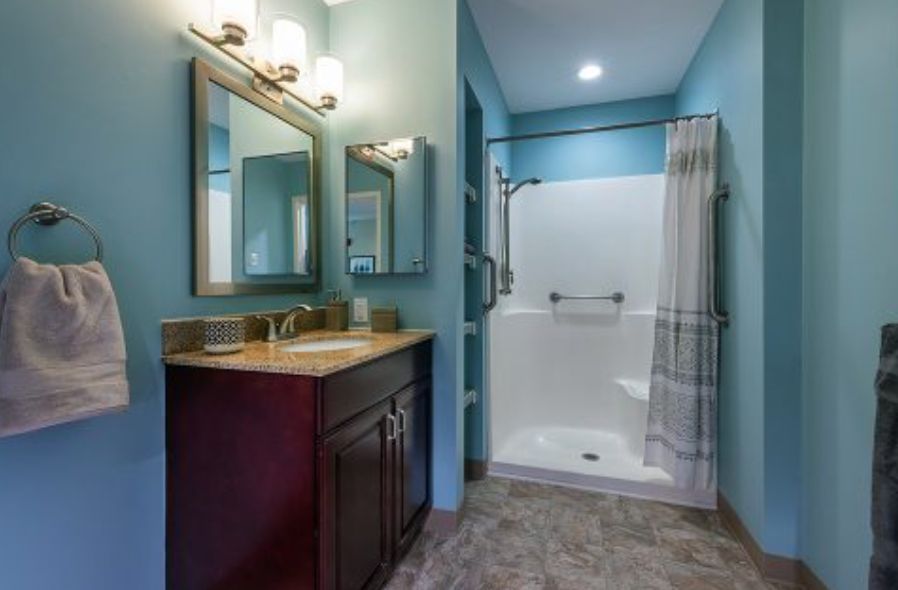 A modern bathroom with a shower, vanity, and stylish lighting.