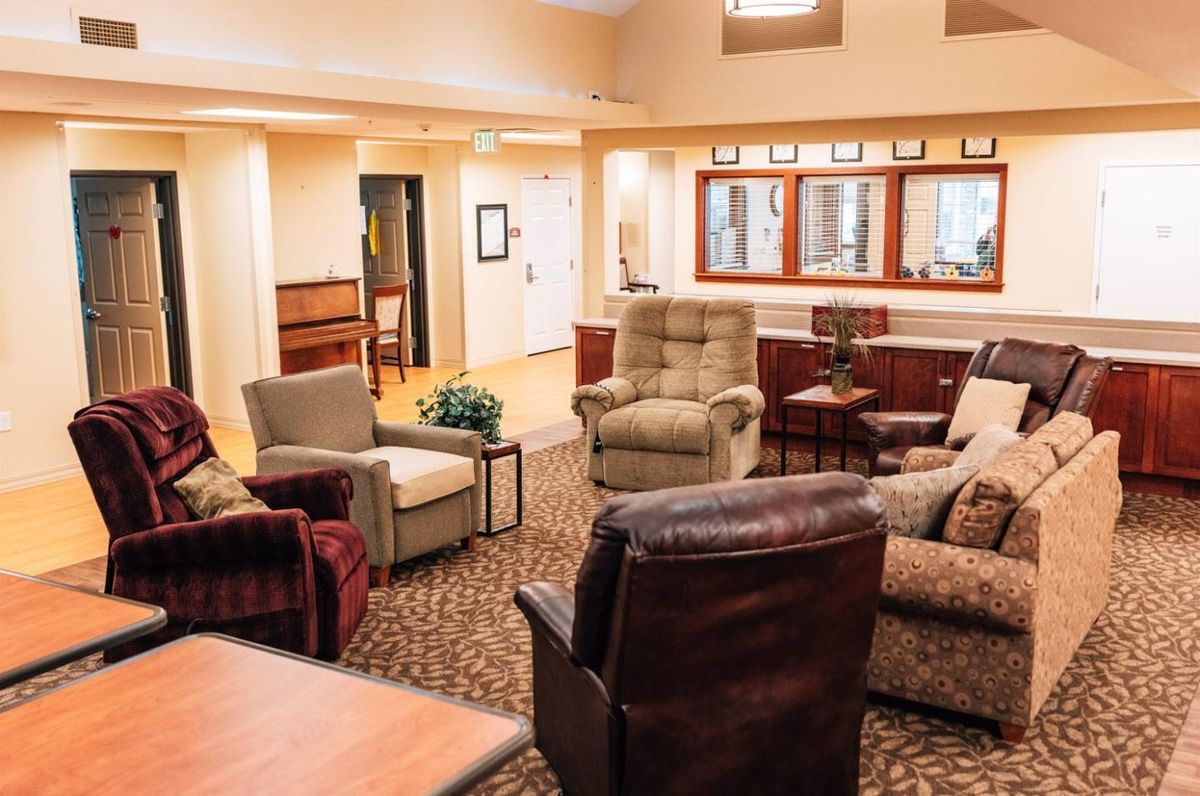 A cozy living room with multiple comfortable chairs arranged in a circle on a patterned carpet.
