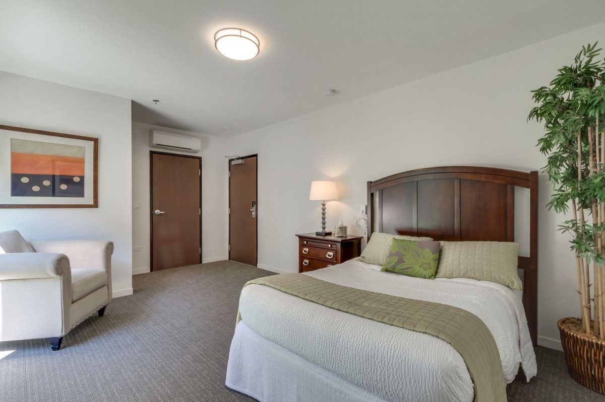 A modern hotel room with a neatly made bed and elegant furnishings.