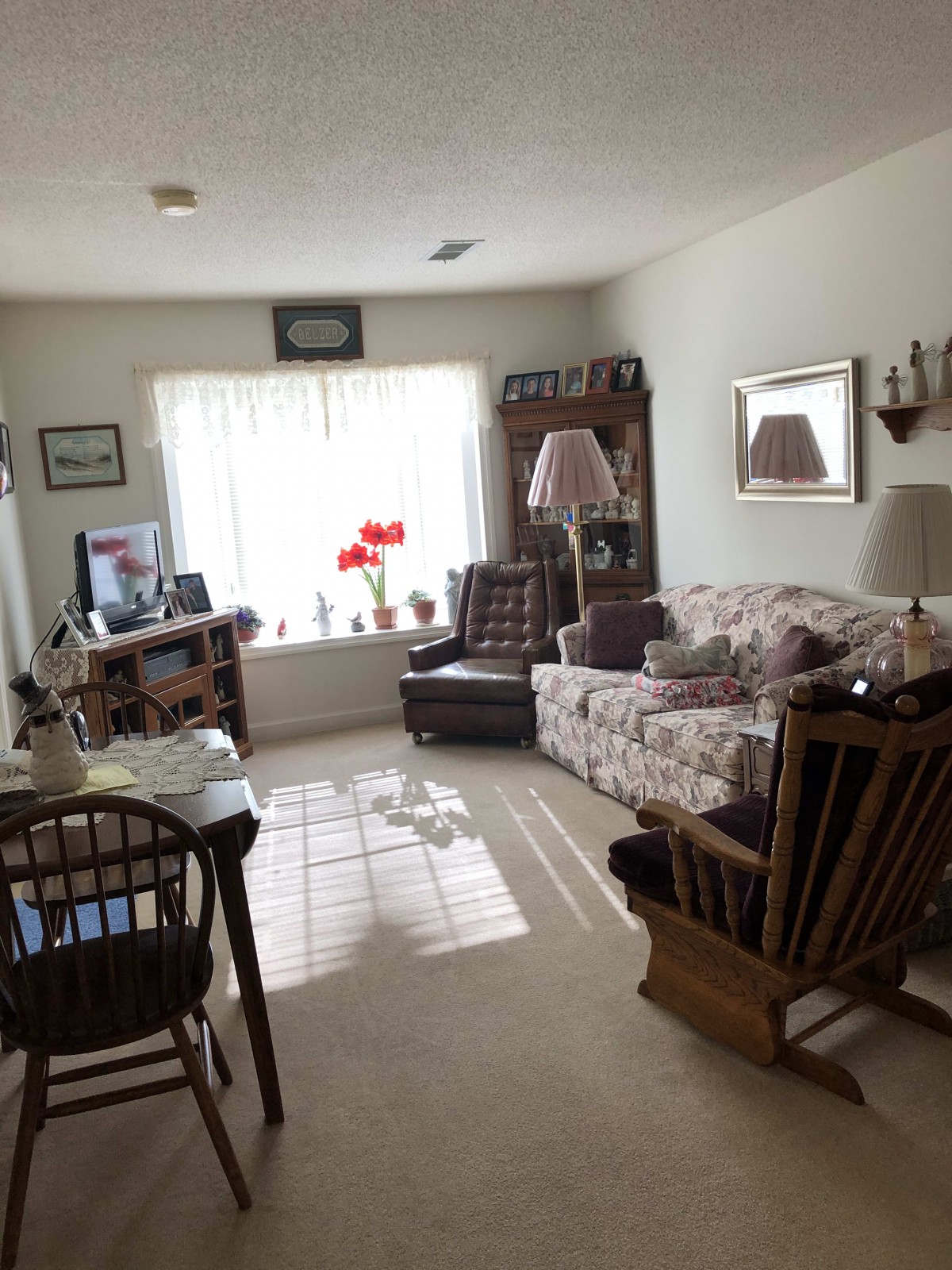 A cozy living room with comfortable furniture and a large window letting in natural light.
