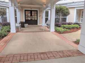 A welcoming entrance to a building with chairs and a small garden.