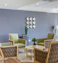 A modern lounge area featuring comfortable chairs, a coffee table, and decorative wall art.