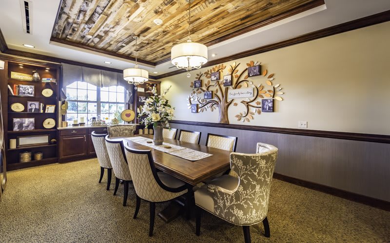 A beautifully decorated dining room with an elegant table setting and warm lighting.