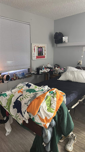 A cozy bedroom setup featuring a bed with colorful blankets and decorative elements.