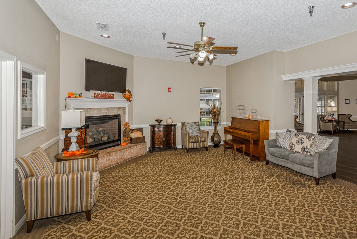 A cozy living room with a fireplace, piano, and comfortable seating.
