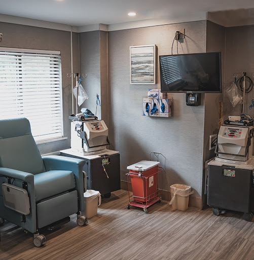 A well-equipped treatment room featuring a patient chair, medical monitors, and essential healthcare tools.