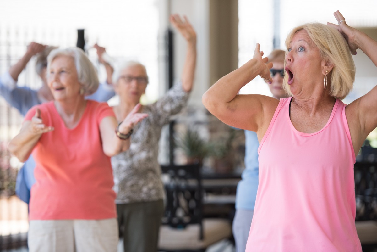 A group of seniors participating in a fitness class indoors.