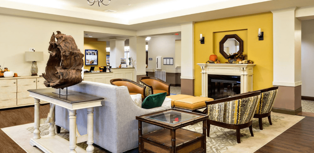 A modern hotel lobby with cozy seating and a fireplace.