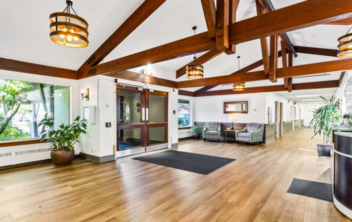 A modern lobby with wooden beams, a seating area, and decorative lighting.