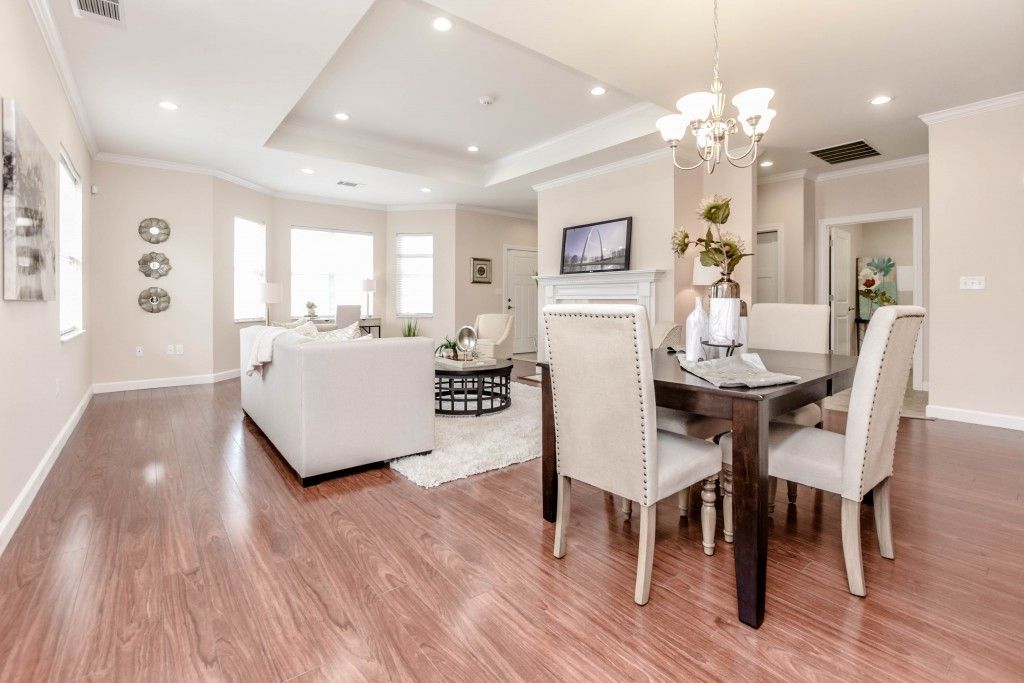A modern open-concept living and dining area with hardwood flooring and neutral colors.
