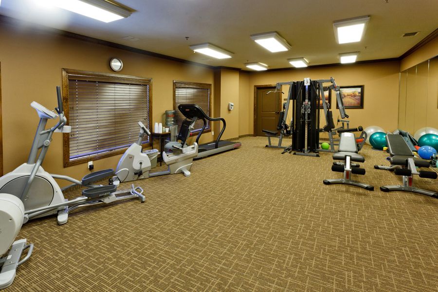 An indoor gym with various exercise equipment including a treadmill and weight machines.