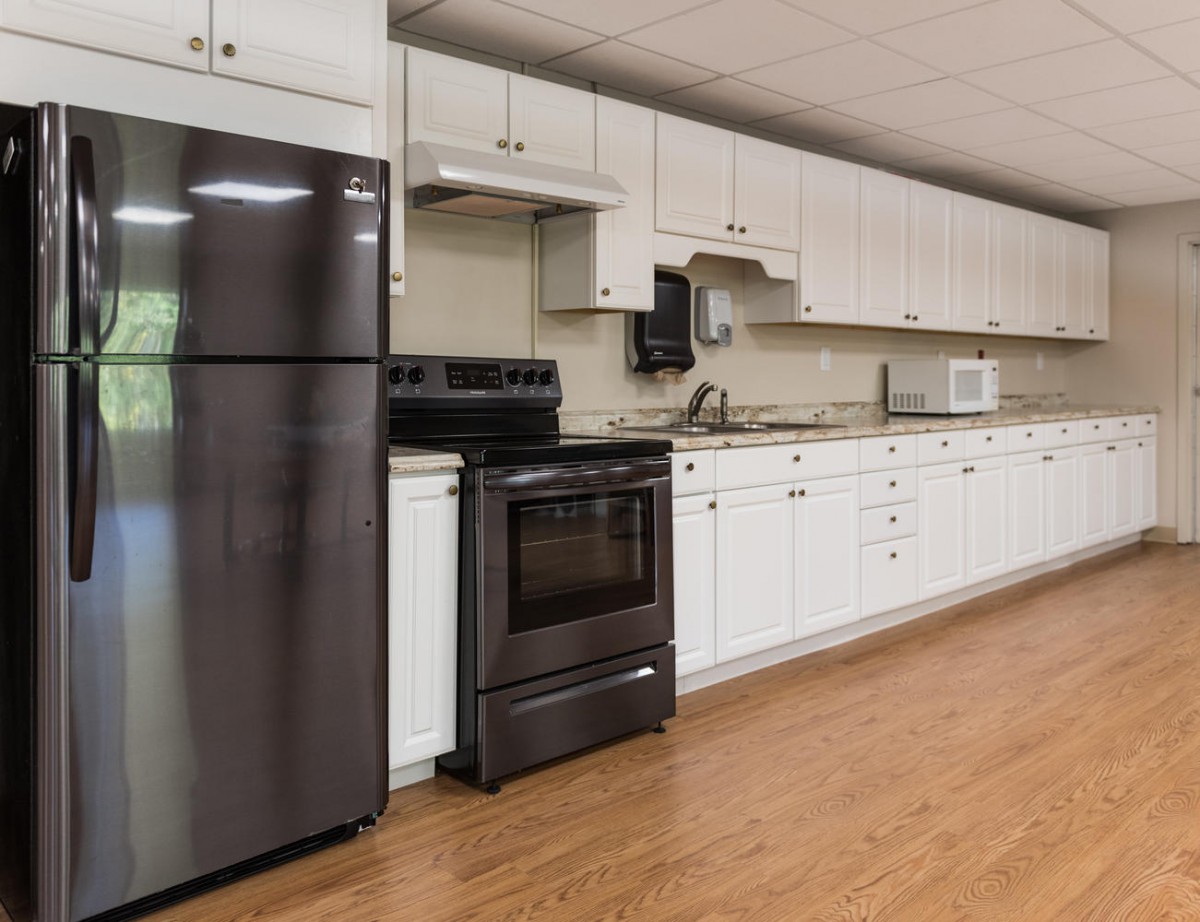 A modern kitchen with white cabinets and stainless steel appliances.