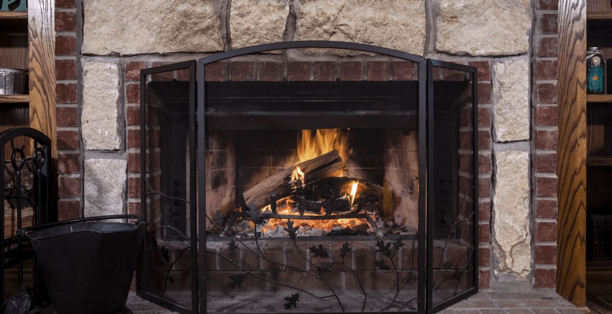 A warm fire burning in a brick fireplace, creating a cozy indoor atmosphere.