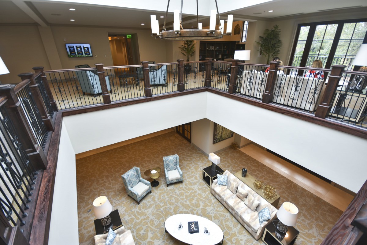 A modern lobby with a spacious seating area, featuring elegant furniture and a decorative chandelier.