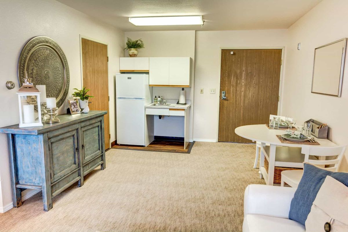 A cozy living area featuring a kitchenette and minimalist furniture.