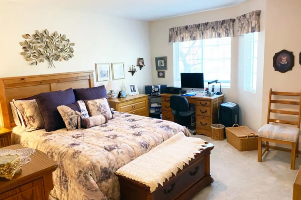 A cozy bedroom with a bed and a computer desk.