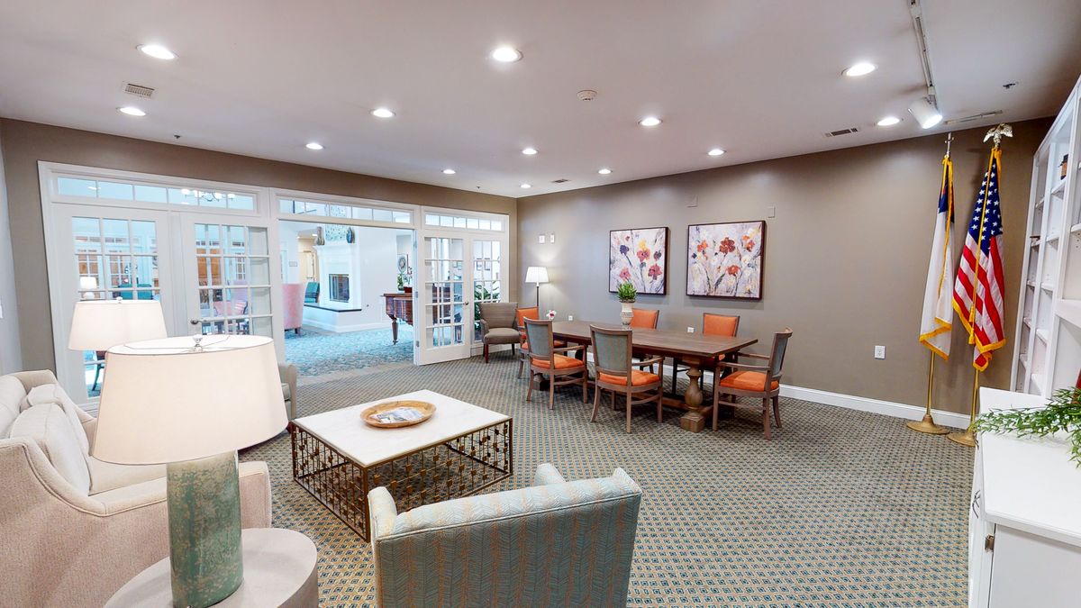A cozy and modern seating area with tables and chairs, decorated with artwork on the walls.