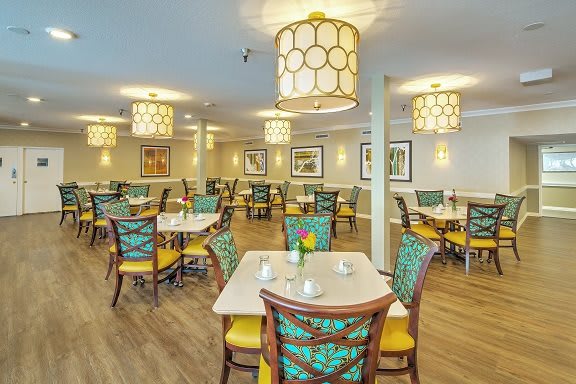 A modern dining room with stylish seating and decorative lighting.