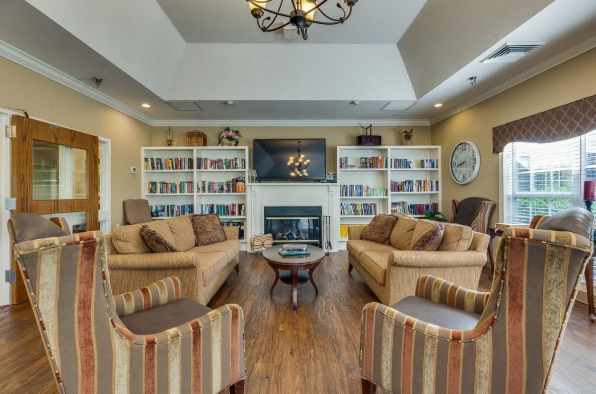 A cozy living room with a fireplace, bookshelves, and comfortable seating.