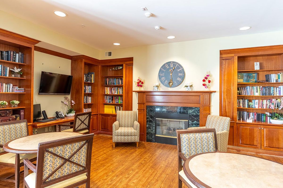 A cozy living room with a fireplace, bookshelves, and comfortable seating.