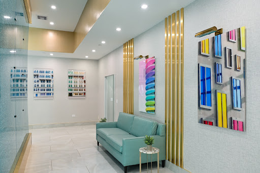 A modern and inviting lobby featuring a turquoise sofa, colorful artwork, and elegant wall accents.