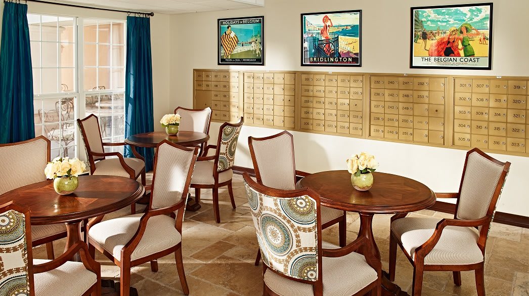 A cozy dining area with elegant chairs and tables, adorned with vibrant artwork on the walls.
