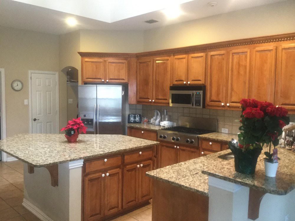A spacious kitchen featuring granite countertops and wooden cabinets.