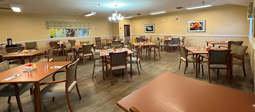 A spacious dining area with tables and chairs arranged for communal dining.