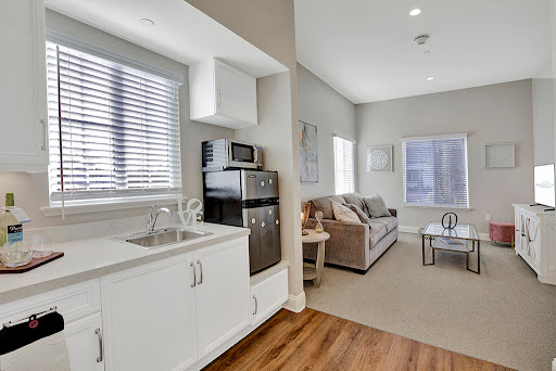 A cozy apartment featuring a modern kitchen and living area, bathed in natural light.