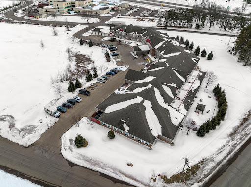 An aerial view of a snow-covered building with a parking lot, showcasing the serene winter landscape.