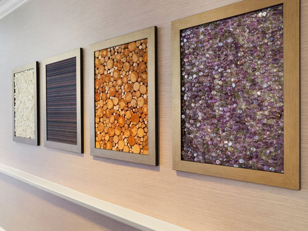 A series of abstract, framed artworks displayed on a wall, each featuring unique patterns and textures.