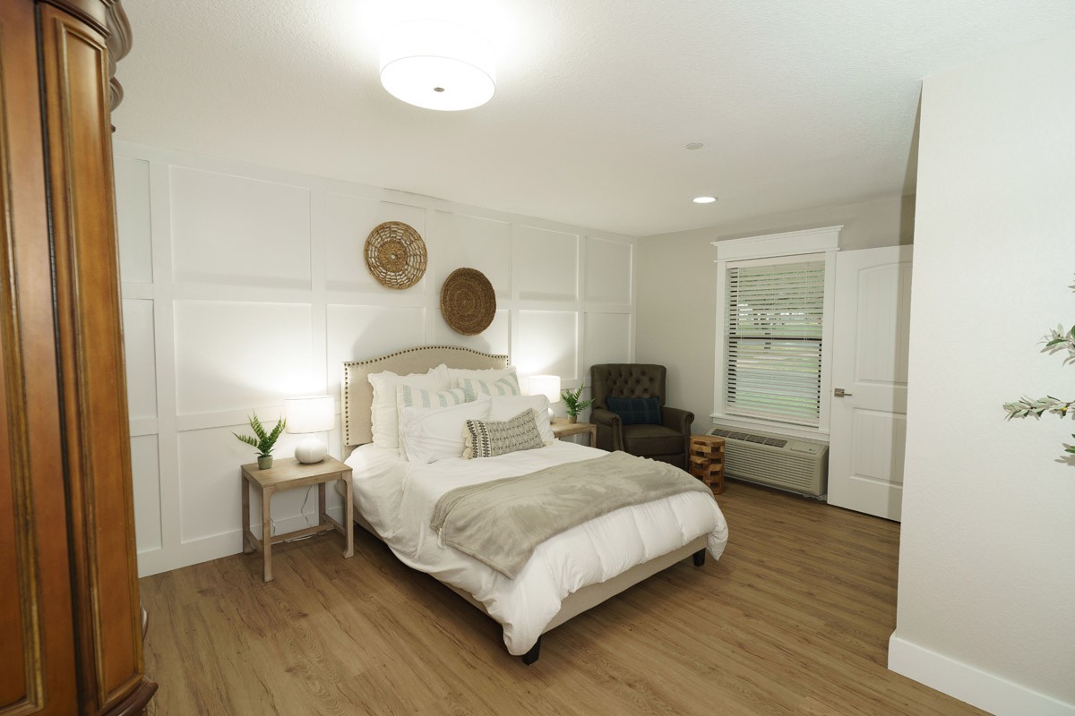A cozy and modern bedroom featuring a comfortable bed, elegant decor, and wooden flooring.