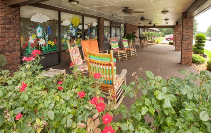 A cozy porch with colorful rocking chairs and vibrant flowers.
