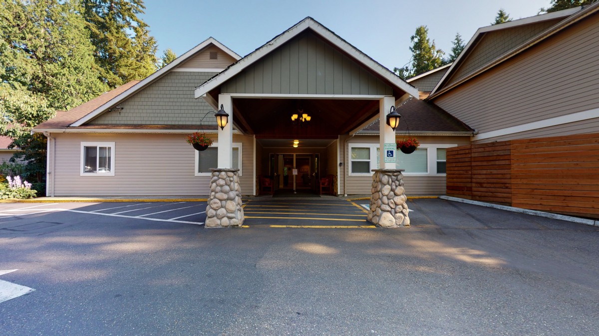 A residential building with a covered entrance and stone pillars.