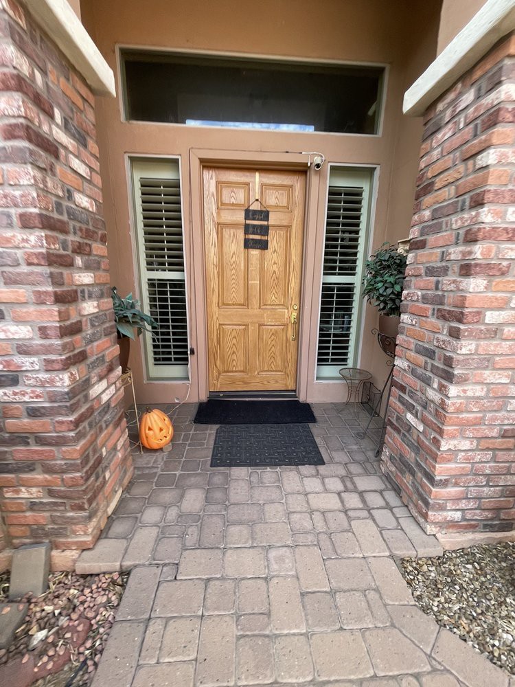 A welcoming front door with brick columns and a pumpkin decoration.