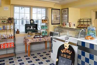A cozy cafe interior with dessert displays and a menu board.