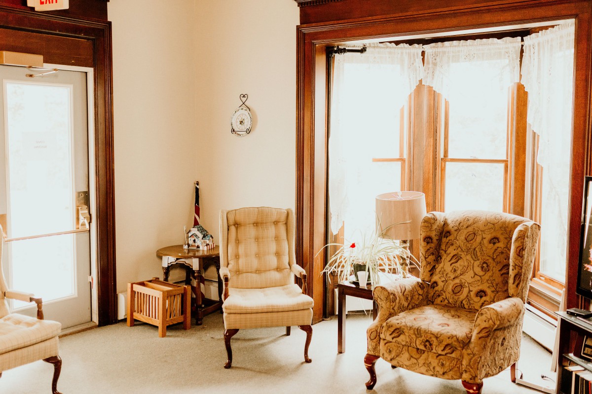 A cozy vintage-style living room with upholstered armchairs and a large window.